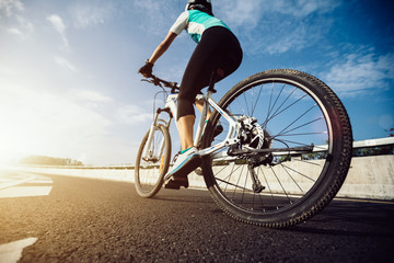Fototapeta premium Woman cyclist riding Mountain Bike on highway