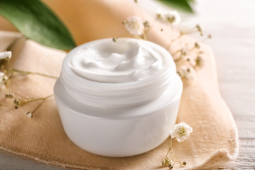 Jar with natural body cream on table