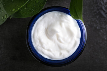Jar with body cream on table, top view