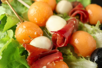 Skewers with melon, prosciutto and mozzarella, closeup
