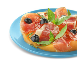 Plate with delicious melon, prosciutto and olives on white background, closeup