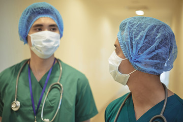 Young Vietnamese surgeon talking to his assistant