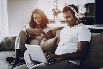 Afro American Couple With Gadgets On The Couch.