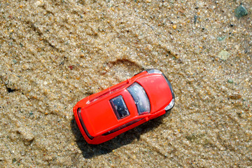 bright red car on the sand, toy car on a summer day