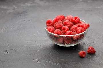 Photo of raspberries in transparent glass cup