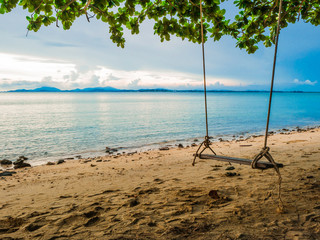 Wooden swing on the Beach beside the ocean in vacation time