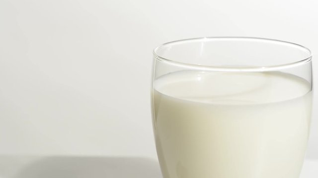Vaso de leche en la mesa blanca, detalle