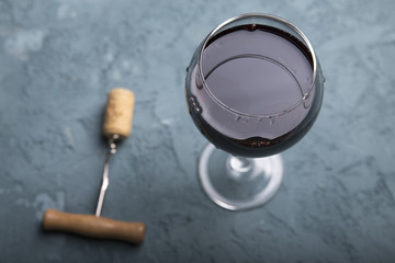 Excellent red wine bottles, wineglass, barrel and corkscrew on a rustic wooden table: traditional...