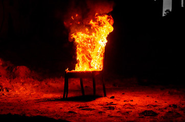 Wooden chair is on fire. Incineration of furniture. Conceptual photo, burnout