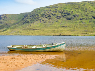Fototapeta na wymiar A Boat on the Beach at Lake Nafooey in Ireland