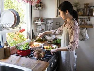 Photo sur Aluminium Cuisinier Femme préparant le déjeuner dans une cuisine