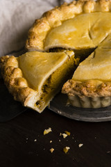 Freshly baked pumpkin pie with a slice cut out