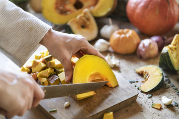 Woman slicing a pumpkin on a cutting board