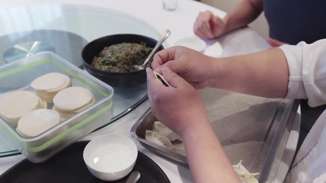 Technology of preparing chinesse dumplings with spinach by handmade. master class how to shape a dough with stuffing inside to make dumplings