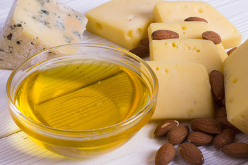 Cheese cuts with figs, nuts, honey, grapes on a wooden boards background