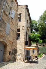 Ville de Pézenas, façade et volet d'une ruelle du centre historique, parasol , table et chaises, département de l'Hérault, France