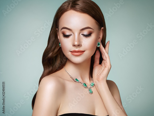 Brunette Girl with Long Healthy and Shiny Curly Hair. Care and Beauty. Beautiful Model Woman with Wavy Hairstyle. Make-Up and Jewelry