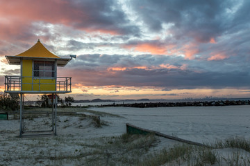 Colourful sky over lifeguard tower on beach