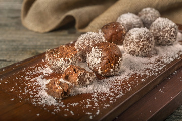 homemade chocolate balls with coconut on a rustic surface