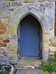 Fototapeta na wymiar Grey Wooden Door Under Stone Archway