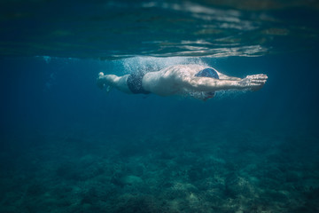 Obraz na płótnie Canvas Man swimming in the sea