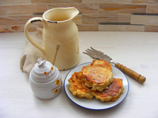 Traditional russian cuisine : pancakes  with oak flakes on  shabby wooden background with rustic milk jug, silver cultery and honey