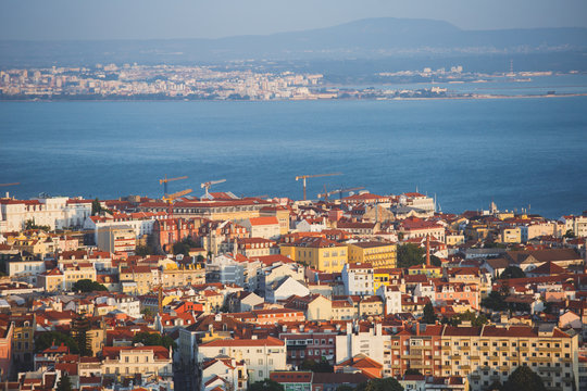 Beautiful super wide-angle aerial view of Lisbon, Portugal with harbor, skyline, scenery beyond the city and 25 de Abril Bridge, over the Tagus river, shot from belvedere observation deck