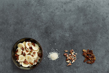 Healthy breakfast concept with oatmeal porridge with bananas,  nuts, raisins, sesame seeds  Top view. Super food. Food made of granola and musli.