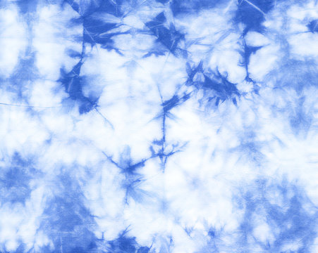 Abstract tie dyed fabric of indigo color on white cotton. Hand painted fabrics. Shibori dyeing