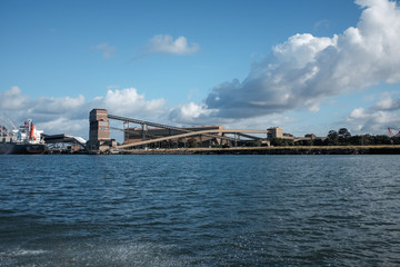 Ship loading dock on harbour beneath cloudy sky