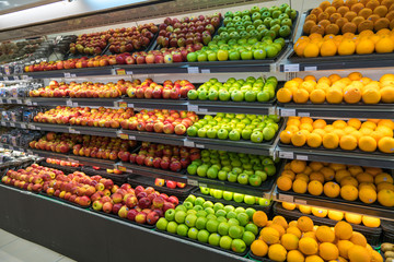 Fresh healthy fruits on shelves in supermarket