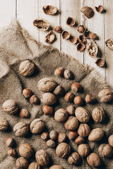 Fototapeta na wymiar top view of hazelnuts and walnuts on sackcloth on wooden table