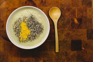Healthy detox dish of  vegetarian  soup with seeds and turmeric and wooden spoon.