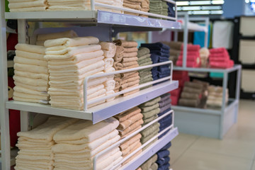 Fototapeta premium Stacks of colored towels on the shelves in supermarket