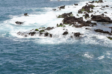 Fototapeta premium rocky coastline, natural volcanic rock, foaming water