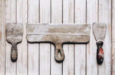 Kit of putty knives. Spatulas with the remaining mortar. Gastarbeiter or guest worker concept. Handyman. Tools for repair.