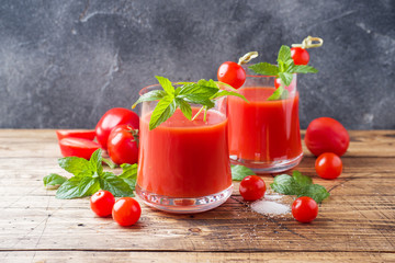 Tomato juice with mint in glass and fresh tomatoes on a wooden table. Healthy organic food concept Copy space