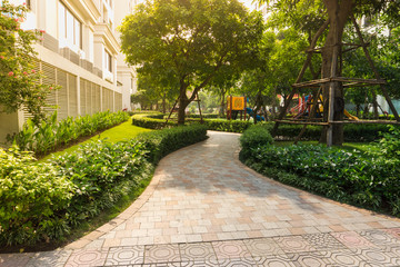 Urban walking road among green tree in modern apartment buildings in big city.