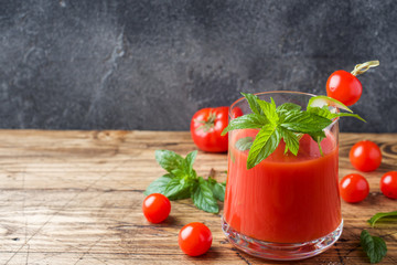 Tomato juice with mint in glass and fresh tomatoes on a wooden table. Healthy organic food concept Copy space