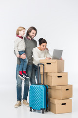 Fototapeta na wymiar happy family using laptop on cardboard boxes isolated on white