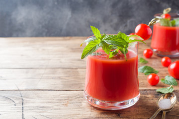 Tomato juice with mint in glass and fresh tomatoes on a wooden table. Healthy organic food concept Copy space