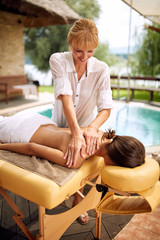 Beauty Spa Treatment-Smiling masseur is massaging a woman at home. - obrazy, fototapety, plakaty