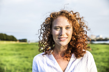 Portrait of freckled young woman with curly red hair