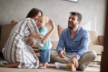 happy loving family.  Smiling mother and father playing with her baby at home.