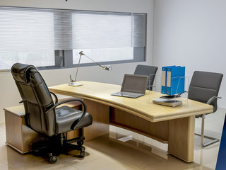 Modern company leadership office, leather chairs, wooden tables, bookshelves, etc.