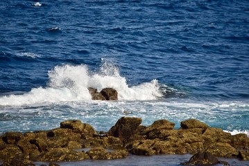 The mighty sea crashing against the rocks on the beach.