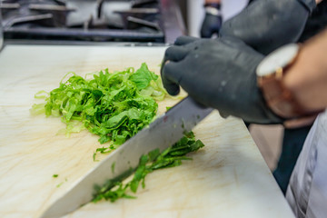 Gourmet, vegan, chef, preparing a vegetarian meal for the homeless, in Italian restaurant. Charity night in Europe, fundraising for local, social balance.