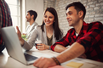 smiling designer people working together at desk on computer.