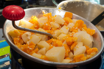 closeup of pumpkin and potatoes mashed in vegetable mill masher