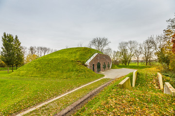 Earthen fortifications with concrete bunkers and  Concrete barracks with brick façade in Werk aan 't Spoel a fortress of the Nieuwe Hollandse Waterlinie